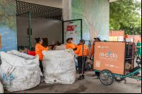 mulheres em meio a sacolas de lixo reciclável