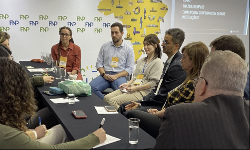 grupo de pessoas discute em torno de mesa