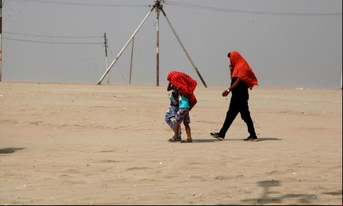 pessoas caminhando no deserto com a cabeça coberta por panos